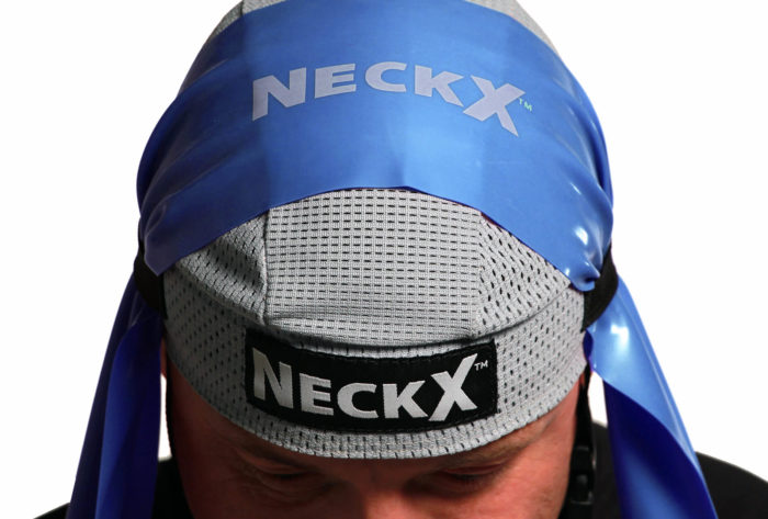 A man wearing a blue hat with the NECK X® TRAINING SYSTEM on it.