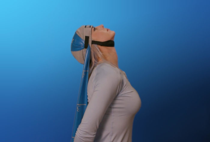 A woman in a blue shirt is holding her head up.