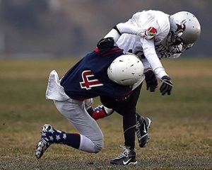A football player is being tackled by another player.