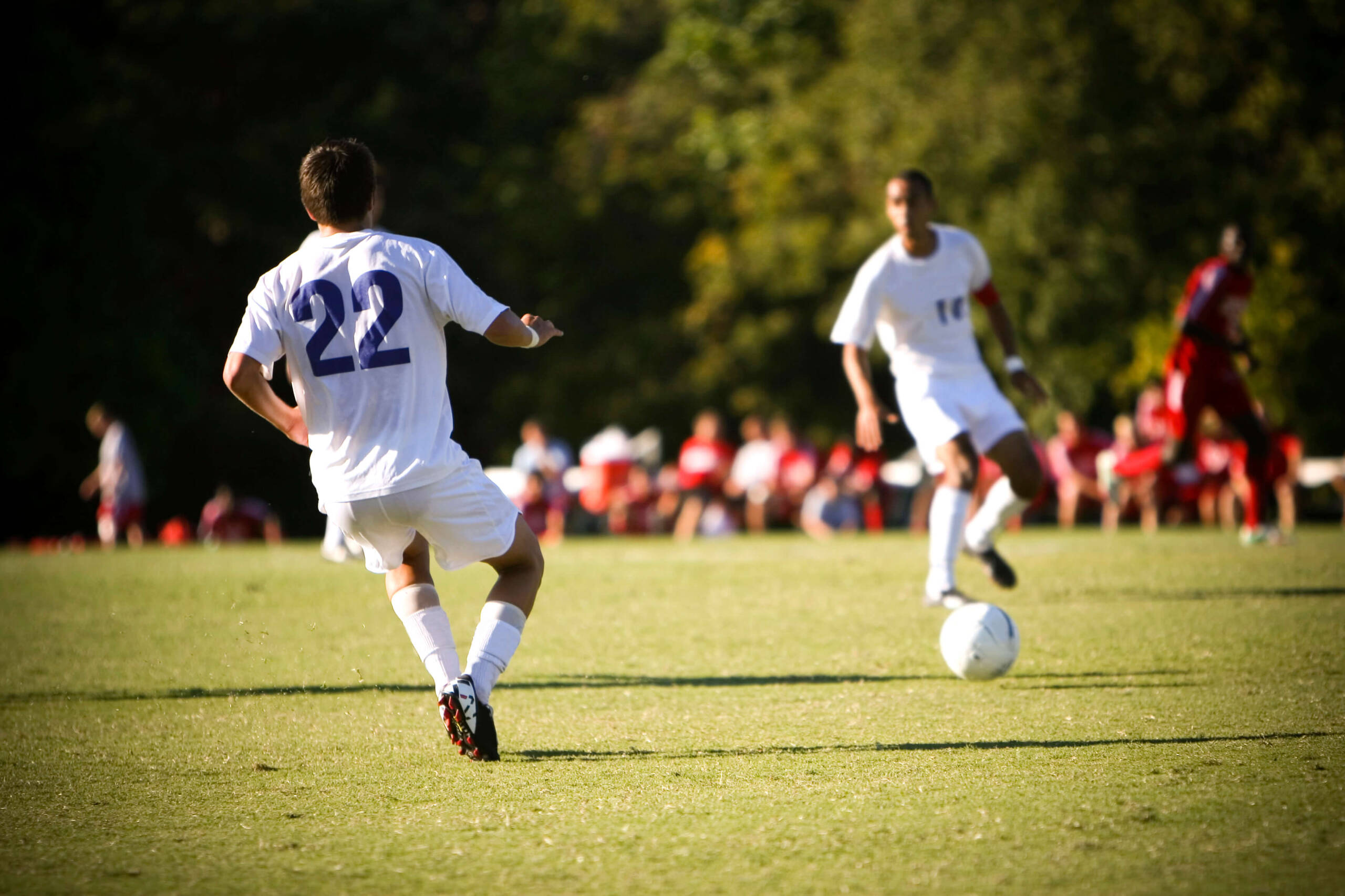A soccer player is kicking a soccer ball.